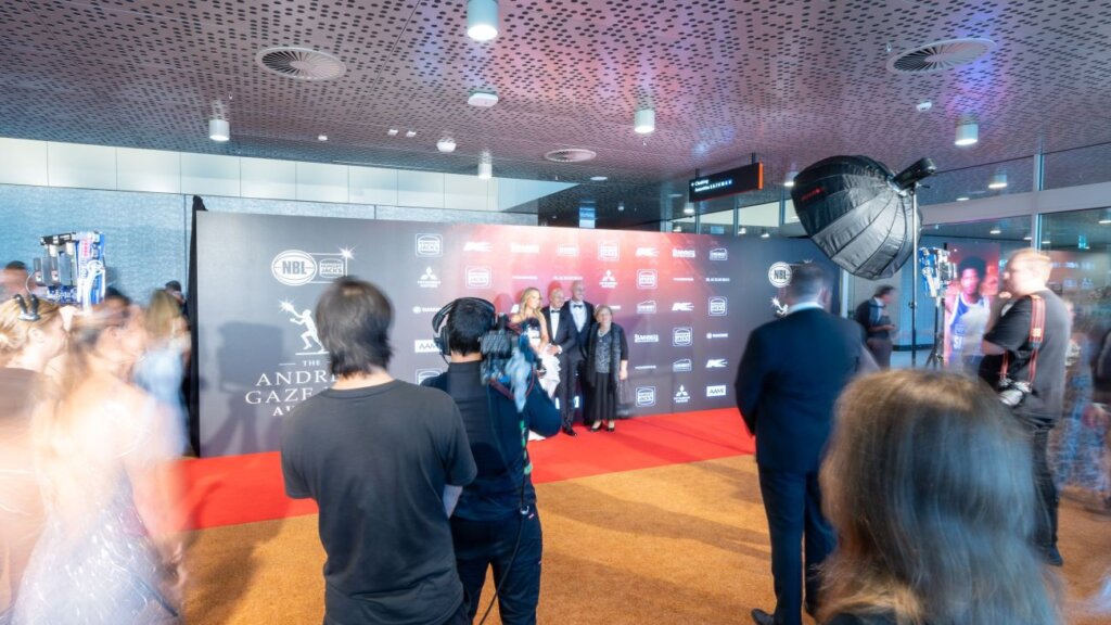 A crowd of people walking the red carpet at the NBL MVP Awards event.